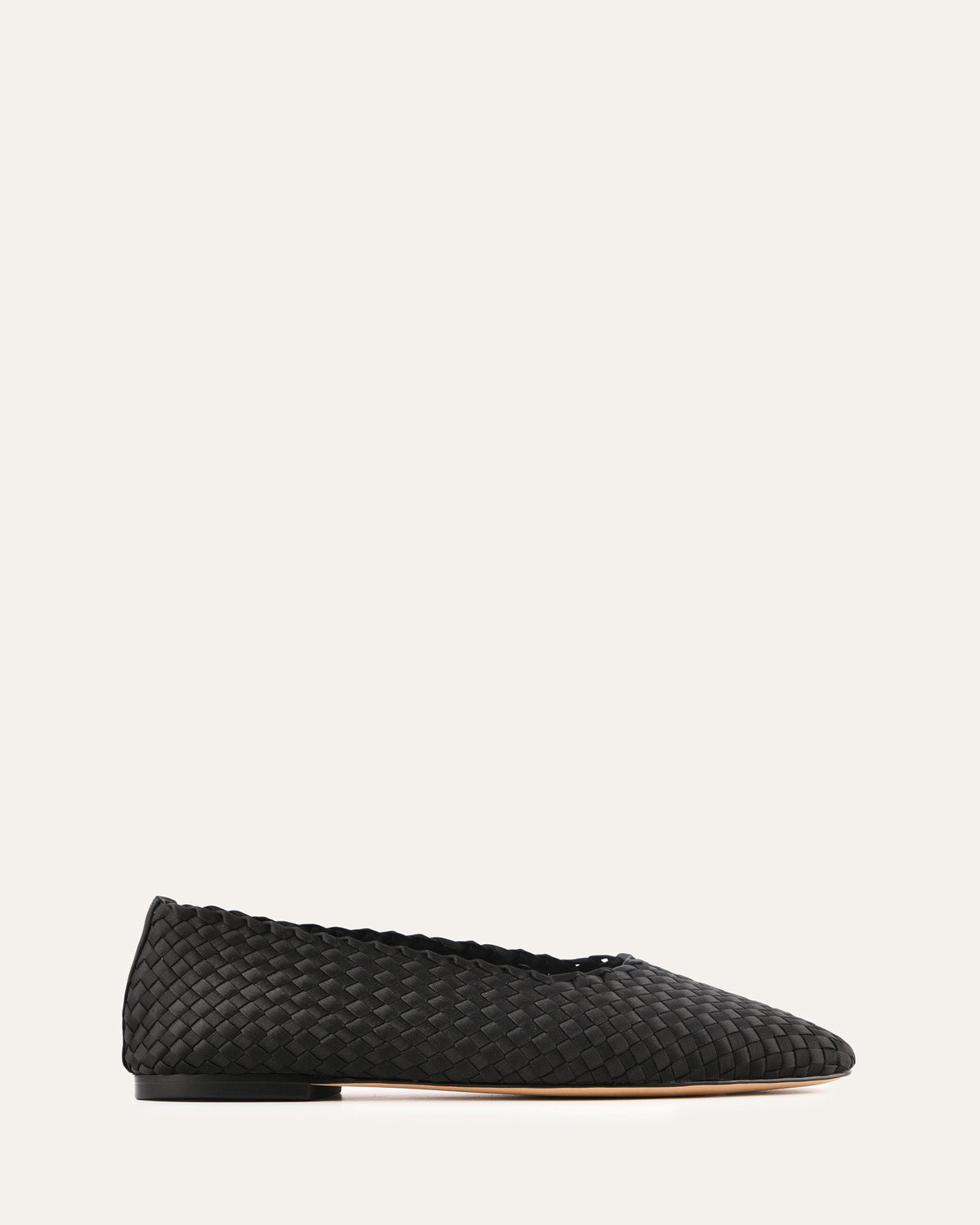 Black woven flat shoe on a light gray background
