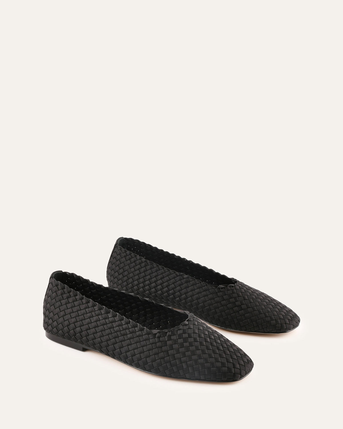 Pair of black textured slippers on a white background