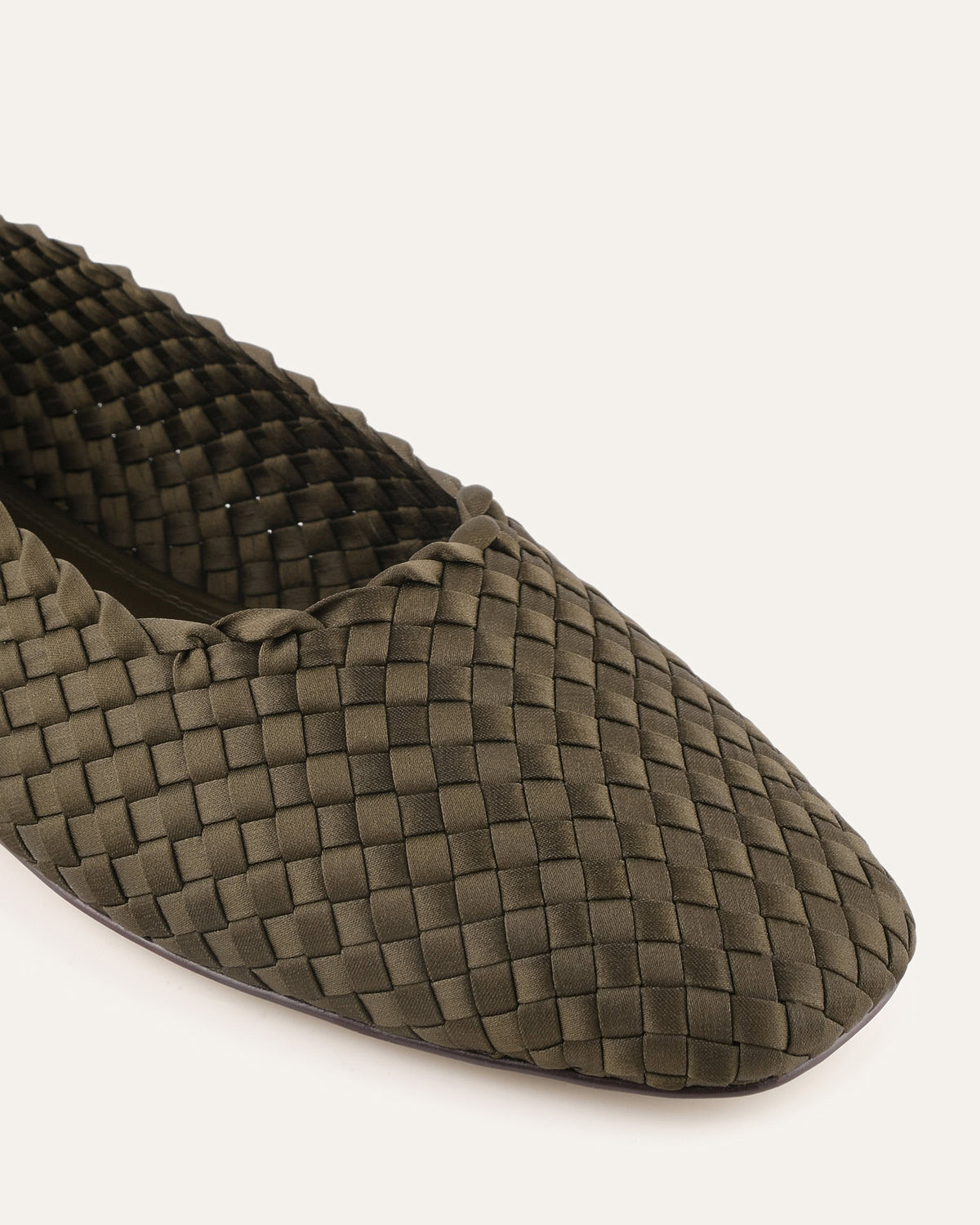 Green woven flat shoe on a white background