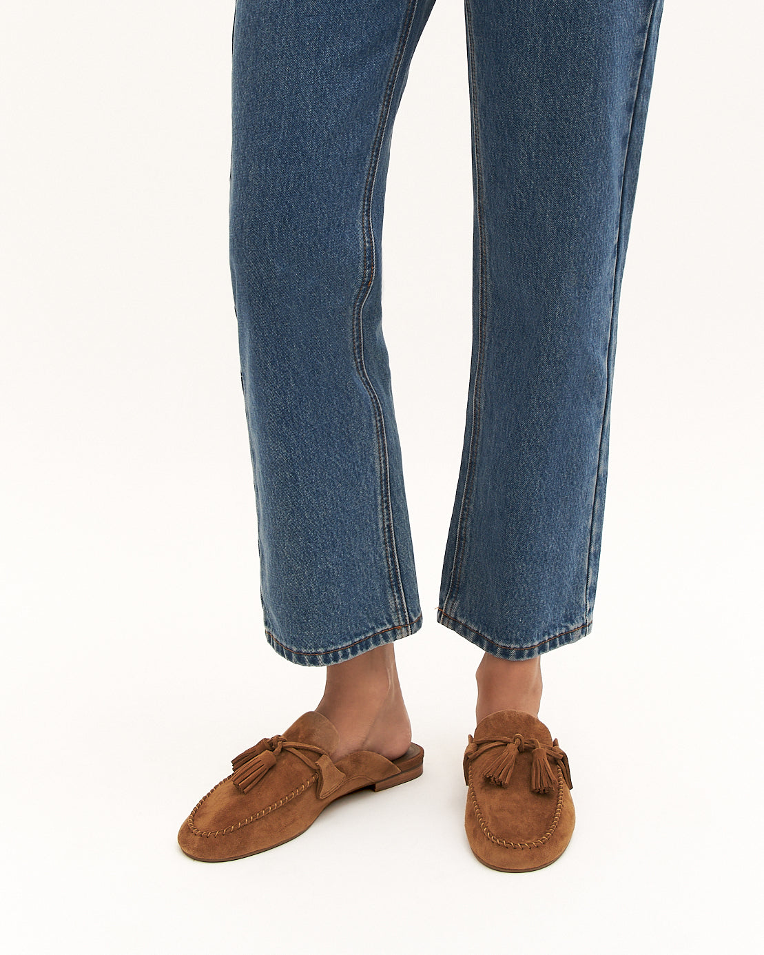 Brown suede loafer with bow detail on a white background