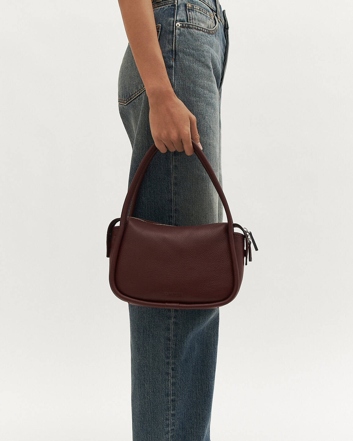 Burgundy handbag on a light beige background