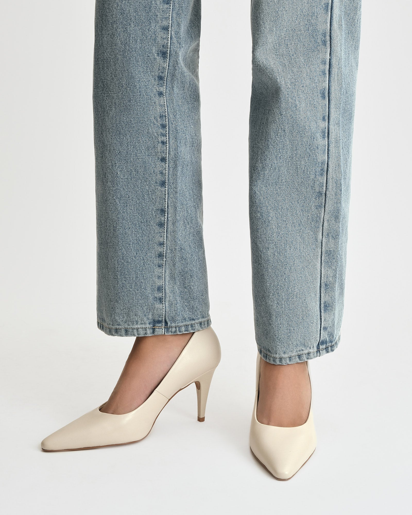 White high-heeled shoe on a light gray background