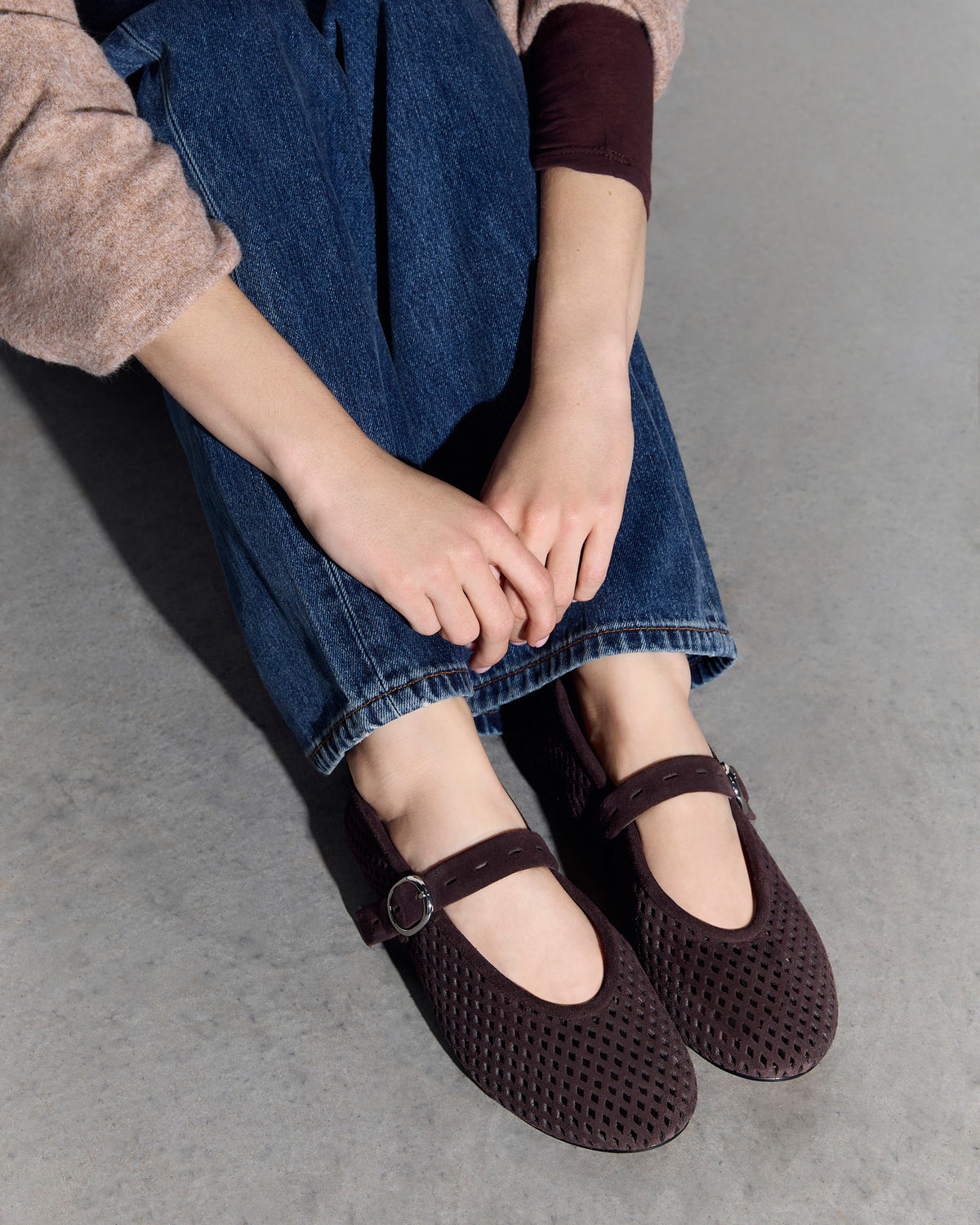 Person wearing brown shoes with a strap on a gray floor