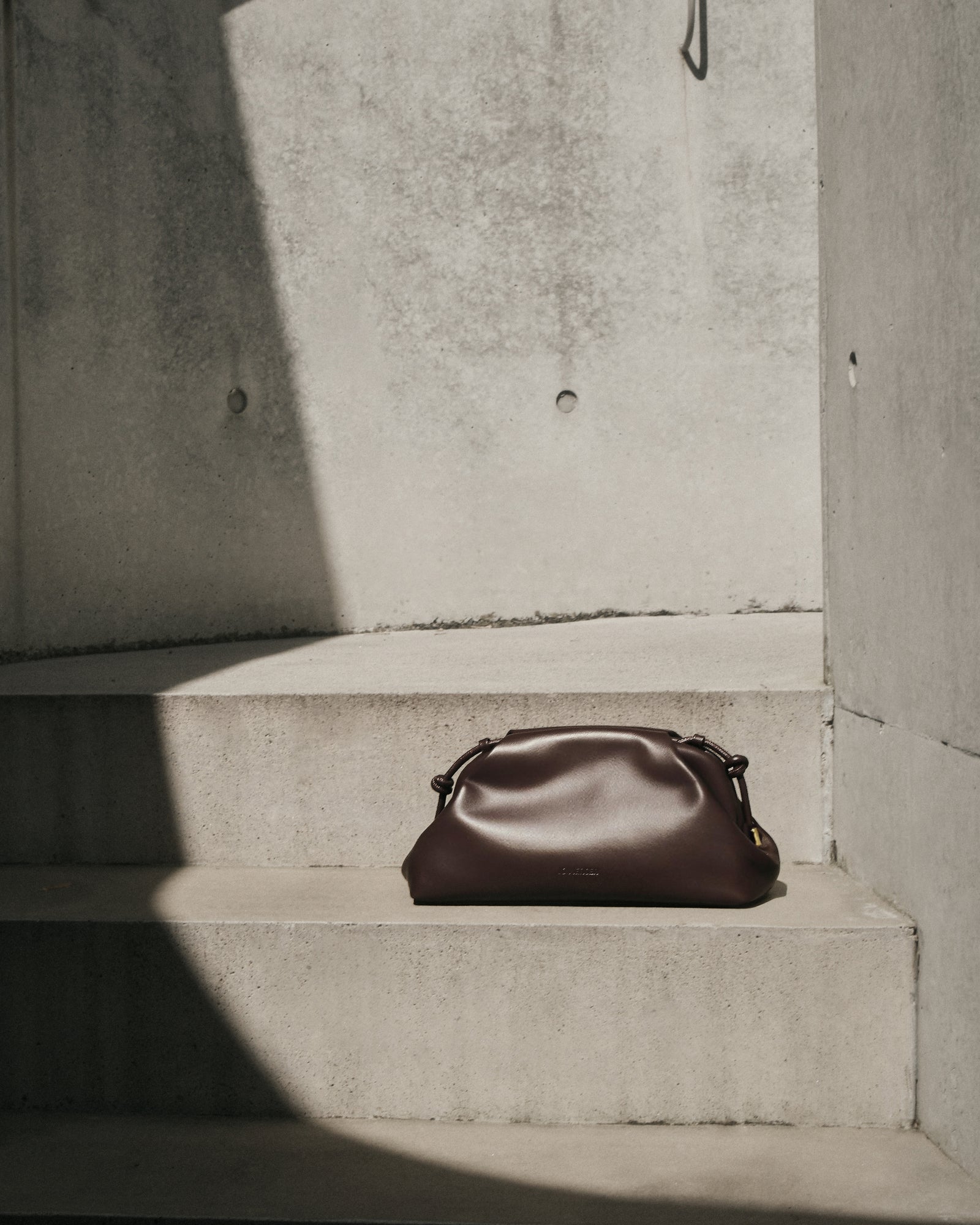 Brown leather handbag on a light beige background