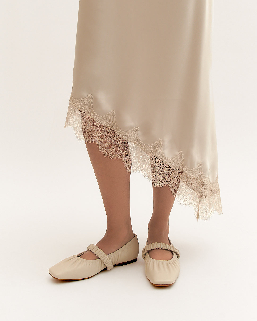 Beige lace skirt and flats on a white background