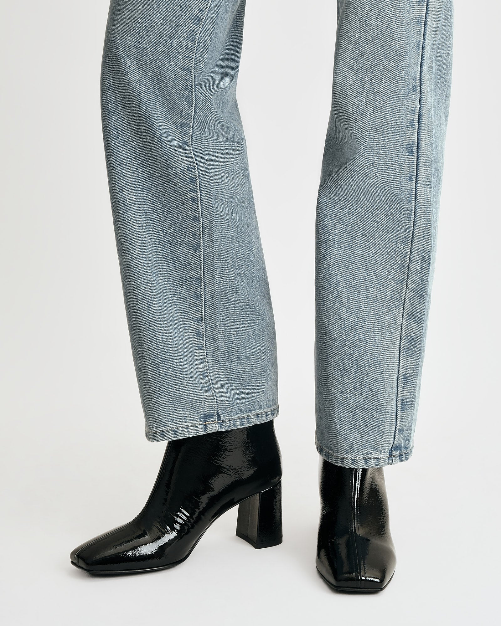 Black patent leather ankle boot on a white background