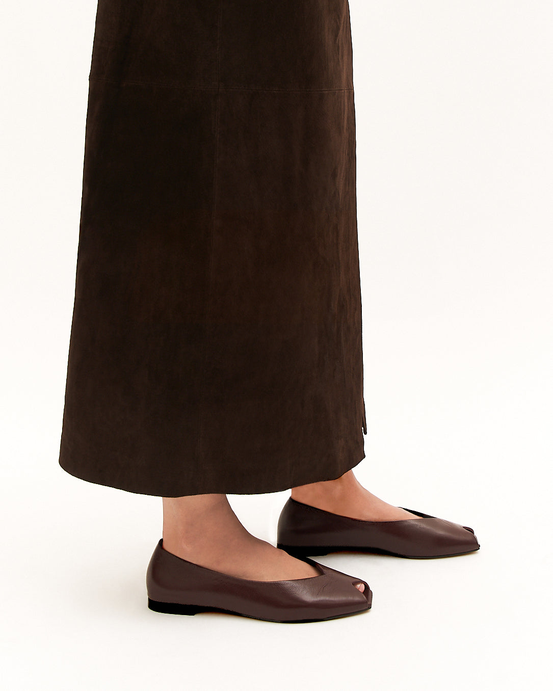 Brown leather flat shoe on a light beige background