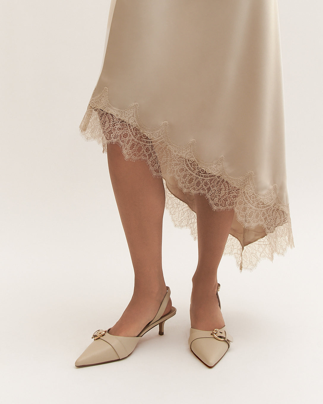 Beige high-heeled shoes with a strap on a white background