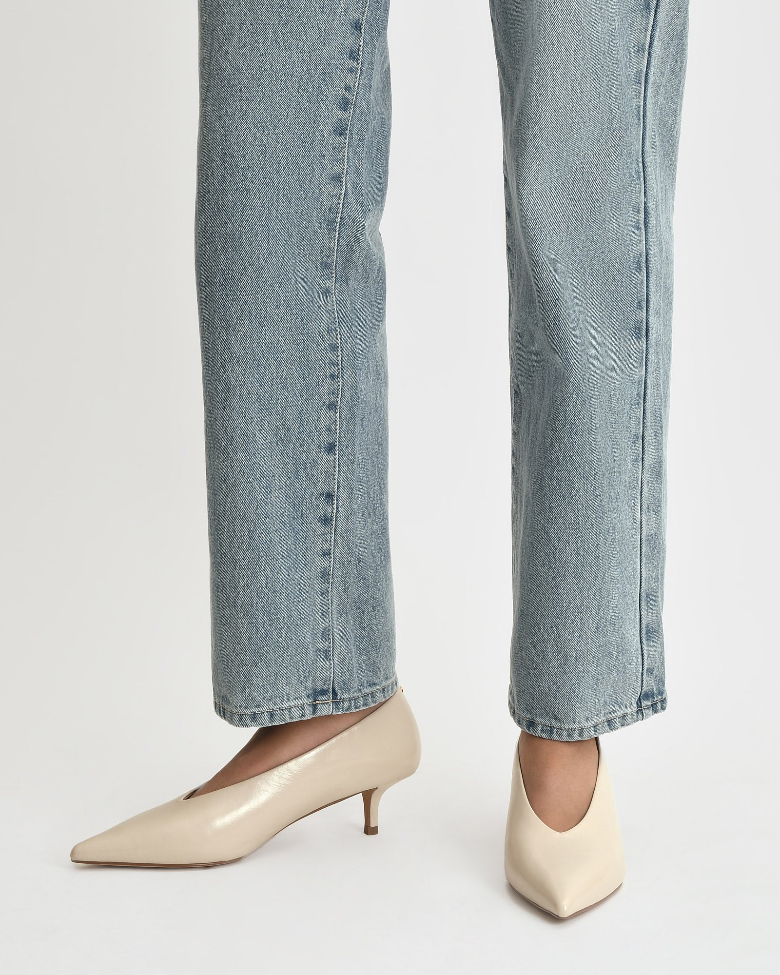 Beige high-heeled shoe on a light beige background