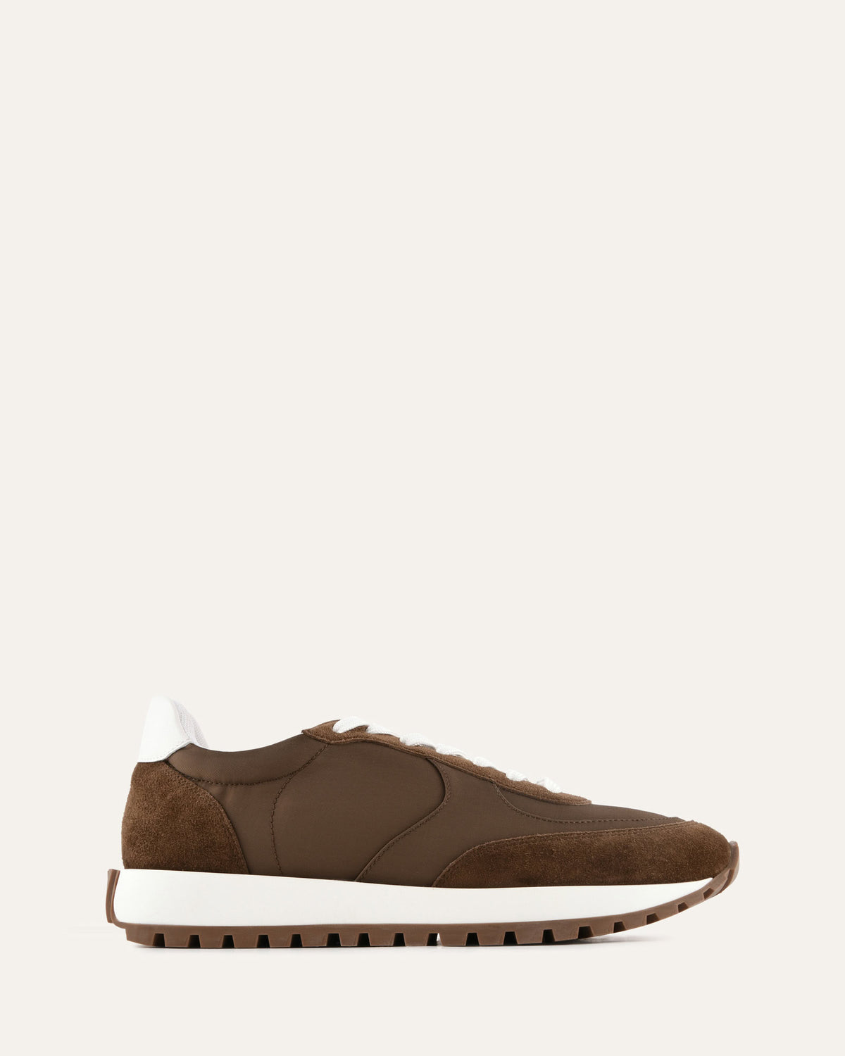Brown sneaker with white sole on a light gray background