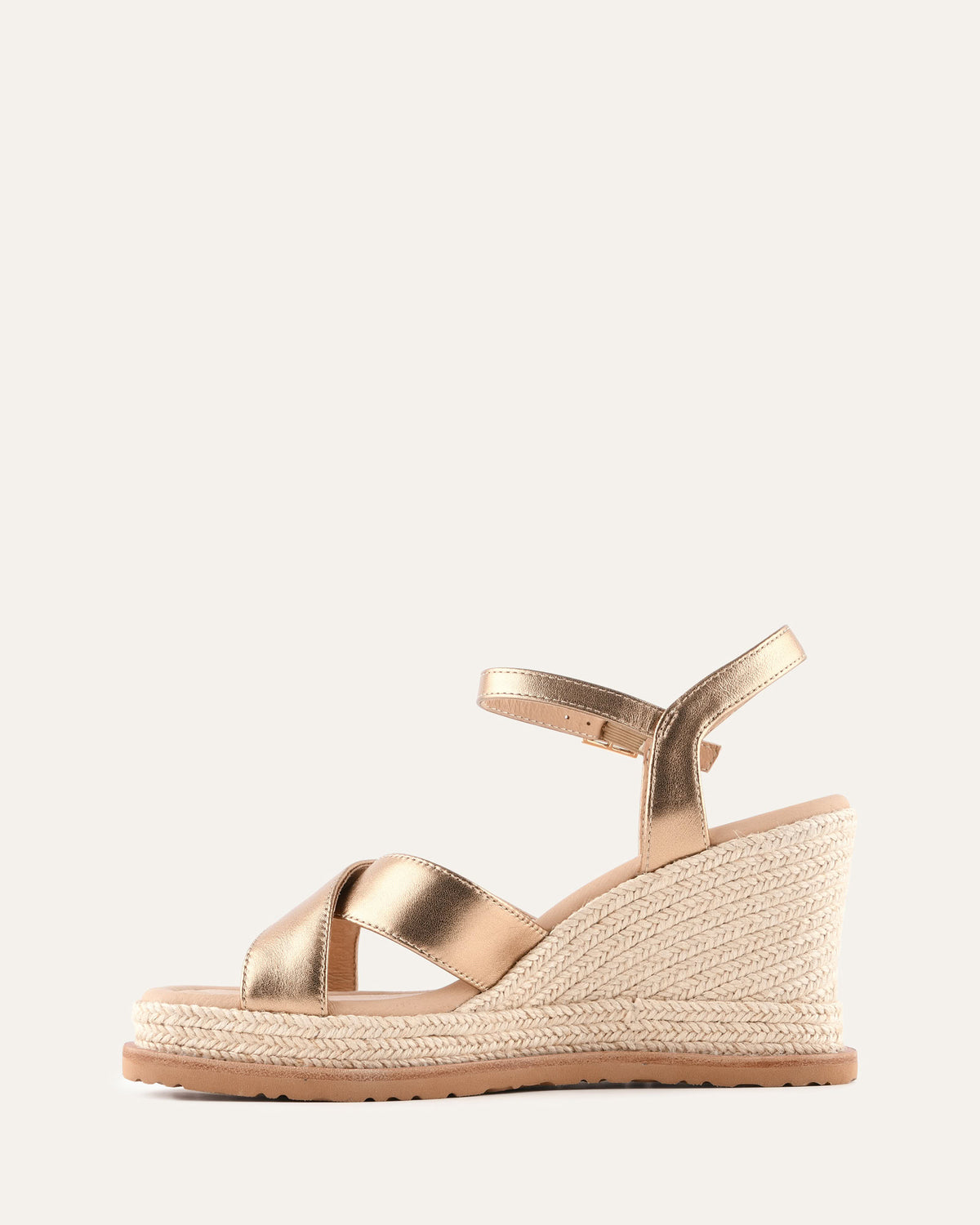 Rose gold wedge sandal with espadrille sole on a light gray background