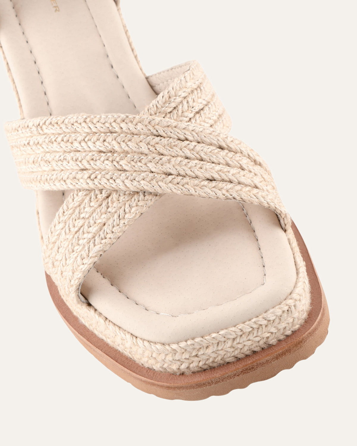 Close-up of a sandal with woven straps on a white background