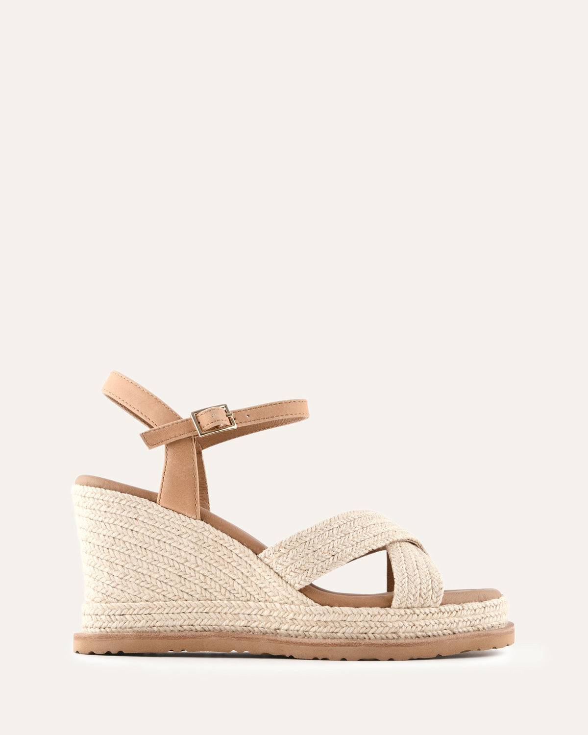 Beige wedge sandal with criss-cross straps on a light beige background
