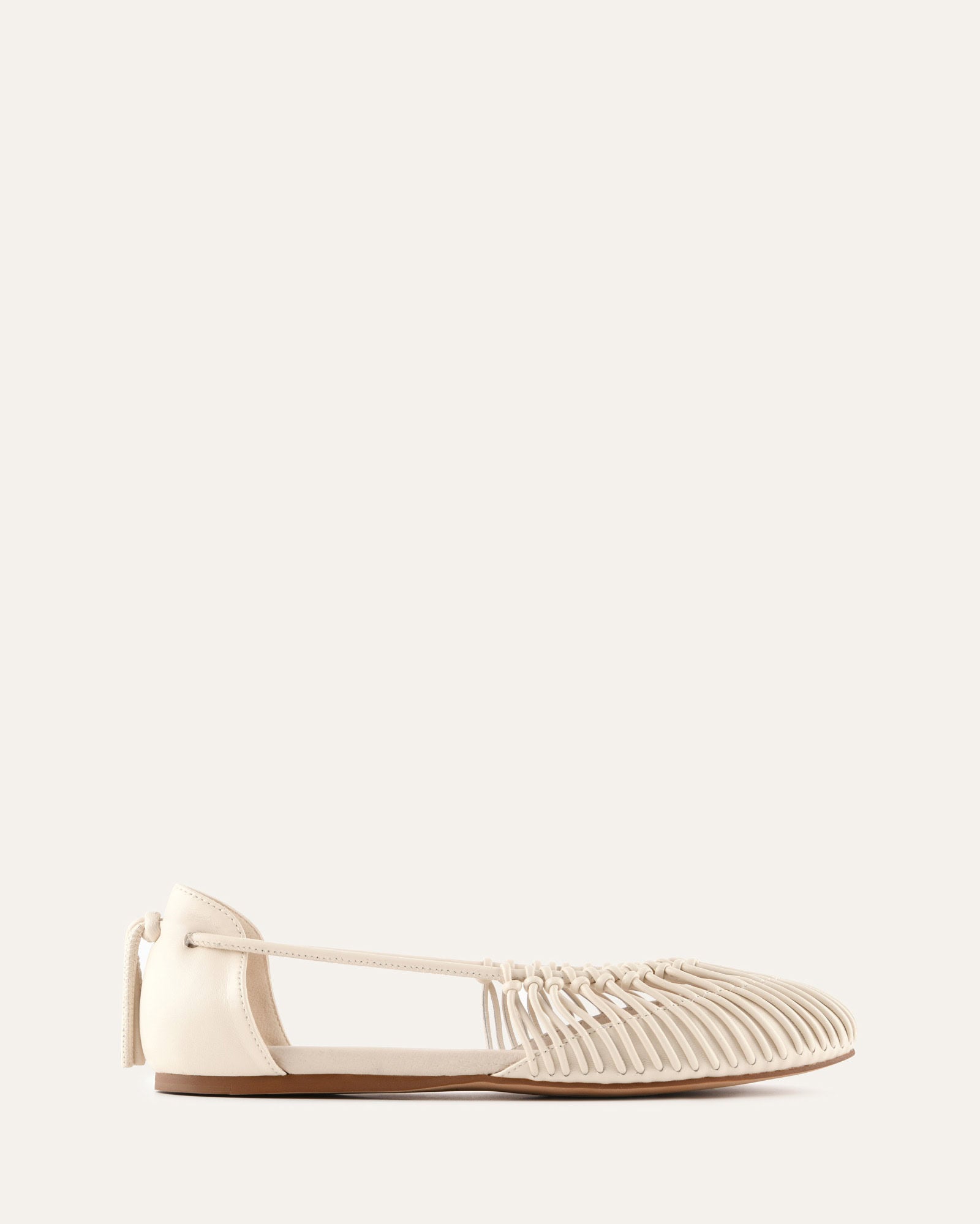 White flat shoe on a light beige background