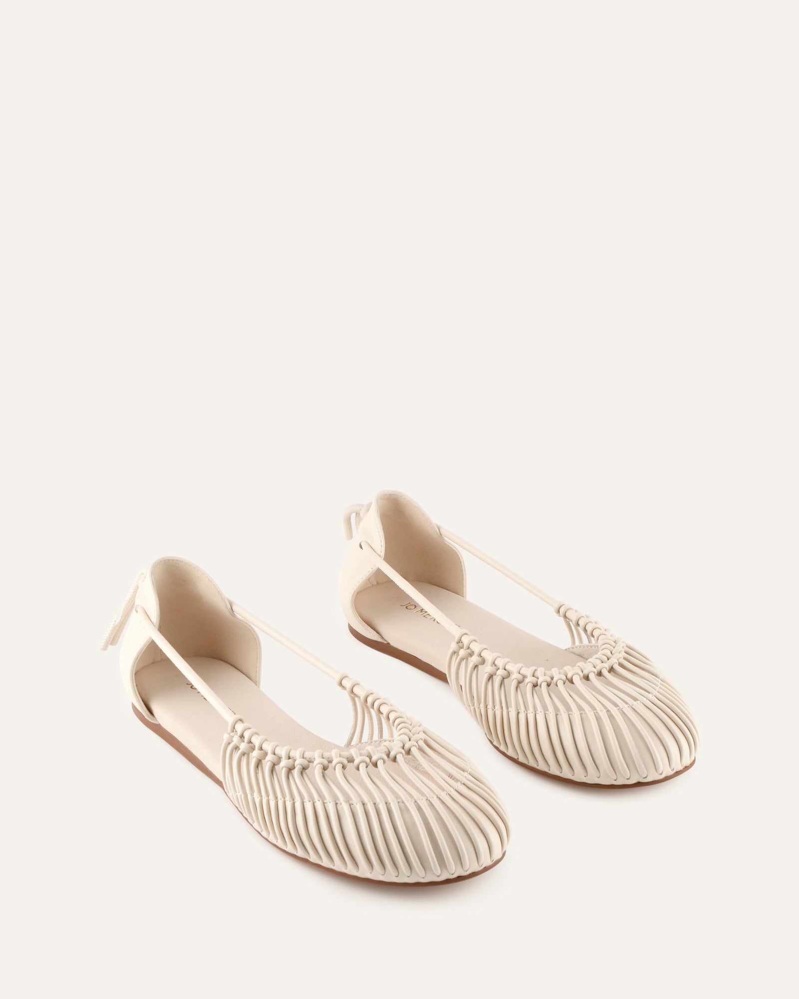 White flat shoe on a light beige background
