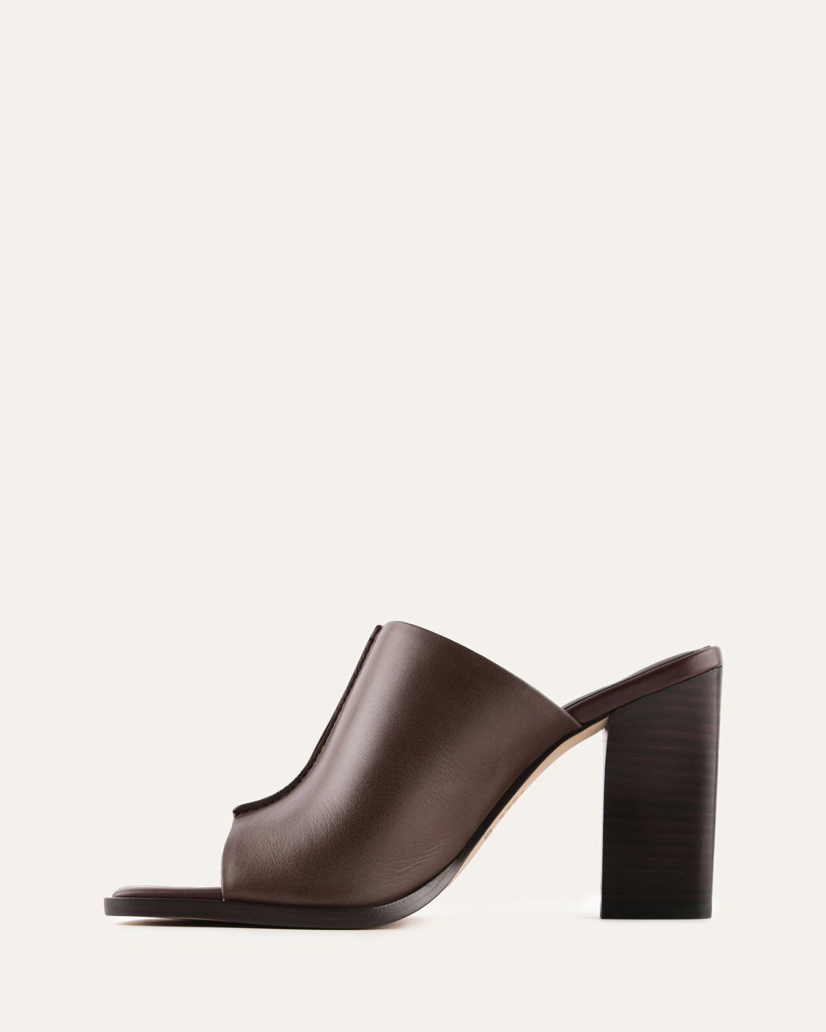 Brown leather heeled shoe on a light beige background